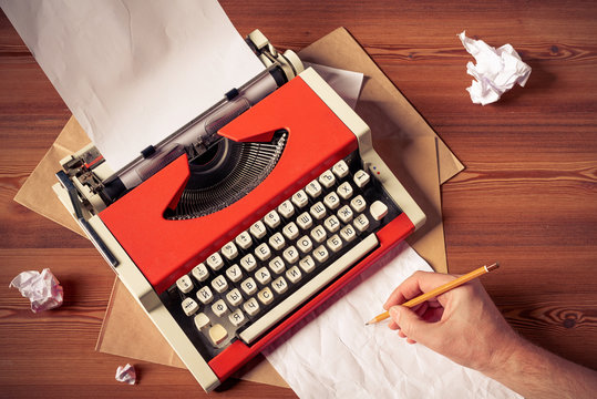 Red vintage typewriter with white blank paper sheet