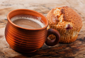 Cup of cappuccino and cake on the old wooden background