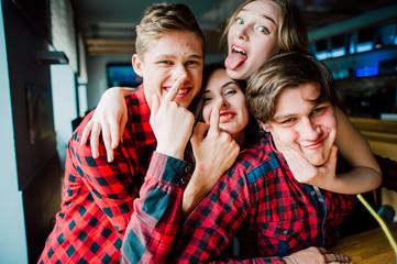 Group of young friends hanging out at a coffee shop. Young men and women meeting in a cafe having fun and drinking coffee. Lifestyle, friendship and urban life concepts.