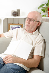 mature man taking a nap in sofa at home