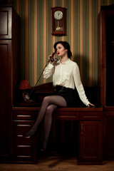 Young woman talking on phone at background of retro Interior.