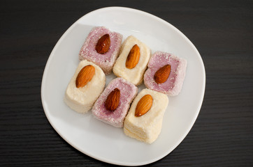 Top view of purple and white Turkish Delight with almonds, black table