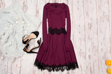 Lilac dress with lace, black shoes and a Imitation fur on a wooden background, fashionable concept,...