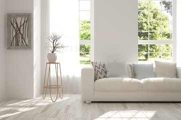 White interior design with sofa and green landscape in window