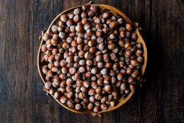 Stack of Hazelnuts in wooden bowl. Top view. Copy space.