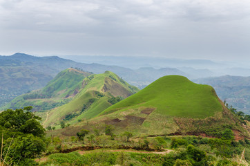 Fototapeta na wymiar Rolling fertile hills with fields and crops on Ring Road of Cameroon, Africa