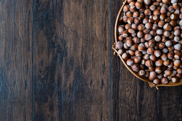 Stack of Hazelnuts in wooden bowl. Top view. Copy space.