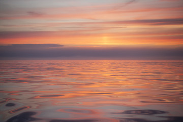 Soft colorful sunset light reflected in the sea waves