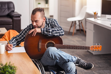 Focused disabled man engaged in songwriting