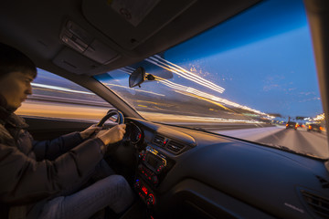 Fototapeta premium Night road view from inside car natural light street and other cars is motion blurred/