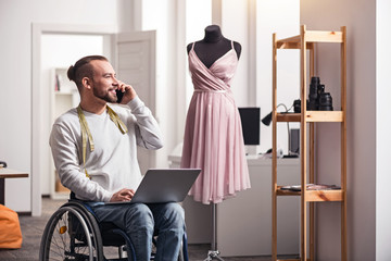 Positive handicapped man discussing details with his colleague