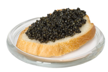 Sandwich with black caviar on white bread on glass saucer, isolated on white background