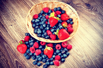 Berries on wooden background. Toned image