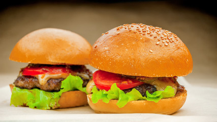 Two homemade burgers on a baking paper