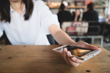 Young woman using smartphone on table.