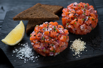 Close-up of salmon tartare served with sesame, bread and lemon
