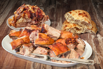 Spit Roasted Pork Ham and Shoulder Slices Served with Pitta Bread on Old Lacquered Cracked Wooden Garden Table