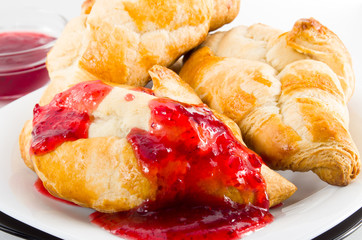 Several croissants smeared with strawberry jam