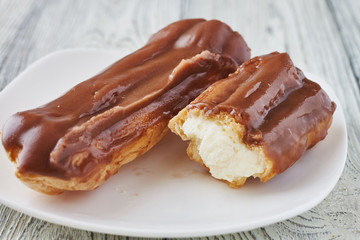 Homemade eclairs with cream and chocolate topping