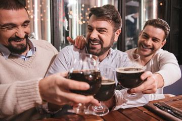 Joyful delighted men drinking alcohol