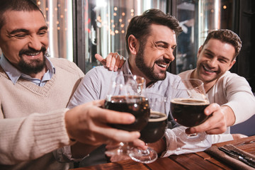 Happy male friends raising their glasses