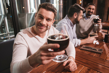 Handsome positive man drinking beer