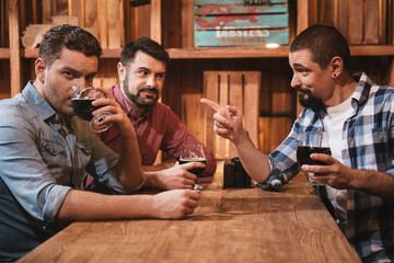 Handsome bearded man pointing at his friend
