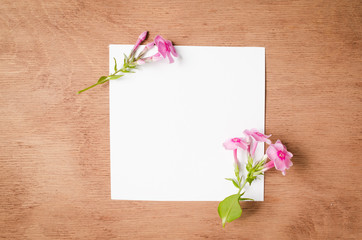 Empty Paper Sheet With Flowers on Rustic Wooden Background.
