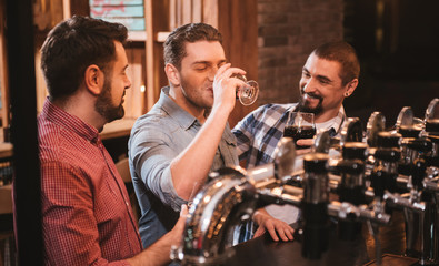 Joyful attractive man drinking beer