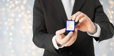 close up of man with engagement ring in gift box