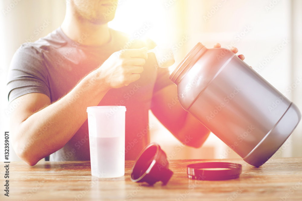 Wall mural close up of man with protein shake bottle and jar