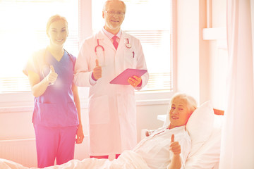 Obraz premium doctor and nurse visiting senior woman at hospital