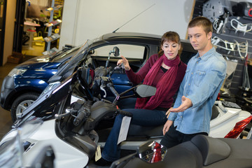 Young man and woman in vehicle showroom