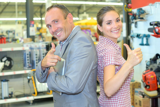 Man and woman in hardware store making positive hand gestures