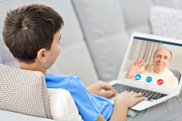 Obraz premium Video call and chat concept. Boy video conferencing on laptop
