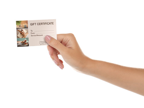 Holiday celebration concept. Female hand with spa service gift certificate on white background