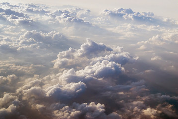 View of clouds from plane in beams of the sunset sun