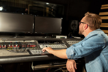 Fototapeta na wymiar man at mixing console in music recording studio