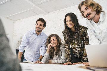 Naklejka premium Young team of coworkers doing a brainstorming in a modern studio