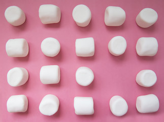 geometric pattern of marshmallows. white marshmallows on a pink background. top view. empty space for your text