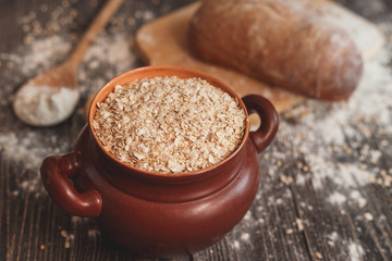 Pot filled with oatmeal on the table  a spoon and homemade bread
