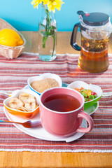 Cup of hot tea with snacks on a tray on the served table. Relax breakfast concept. Selective focus