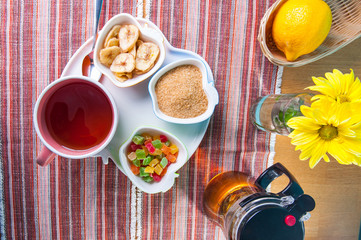 Top view Cup of hot tea with snacks on a tray on the served table. Relax breakfast concept. Selective focus