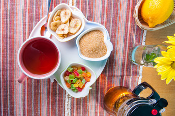 Top view Cup of hot tea with snacks on a tray on the served table. Relax breakfast concept. Selective focus