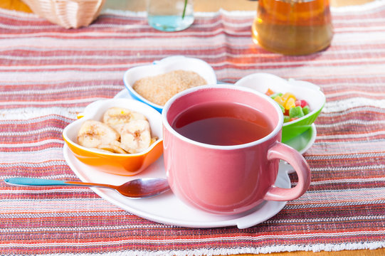 Cup of hot tea with snacks on a tray on the served table. Relax breakfast concept. Selective focus