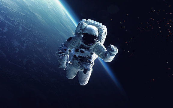 Astronaut at spacewalk. Cosmic art, science fiction wallpaper. Beauty of deep space. Billions of galaxies in the universe. Elements of this image furnished by NASA