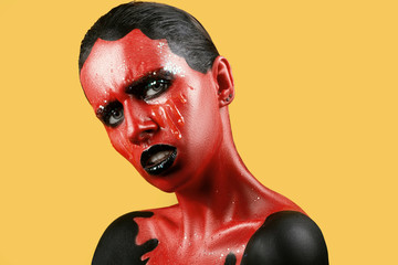 Fantastic girl with red skin on a yellow background and white teeth and black lips