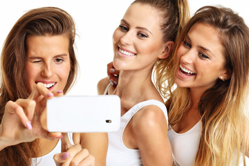 Group of happy friends taking selfie in underwear
