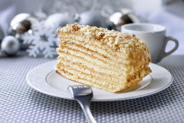 Piece of layer cake with custard and walnuts on a plate 
