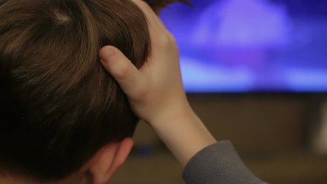 Young Boy Watching TV At Home View From Back